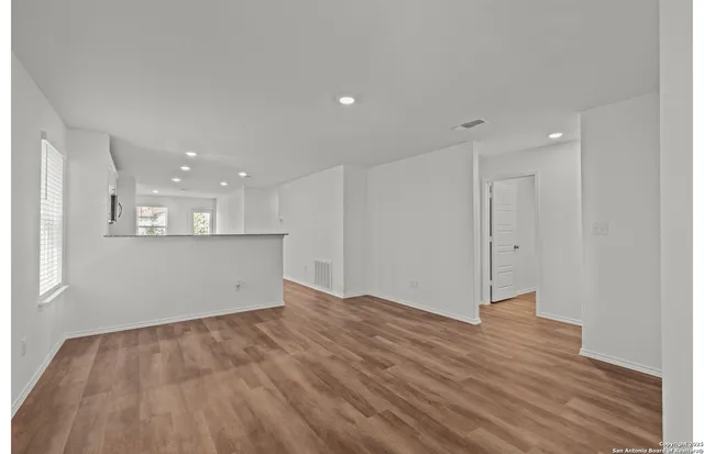 a view of empty room with wooden floor