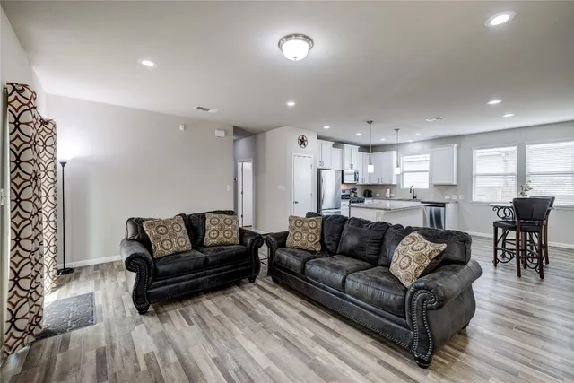 a view of kitchen with kitchen island microwave and wooden floor