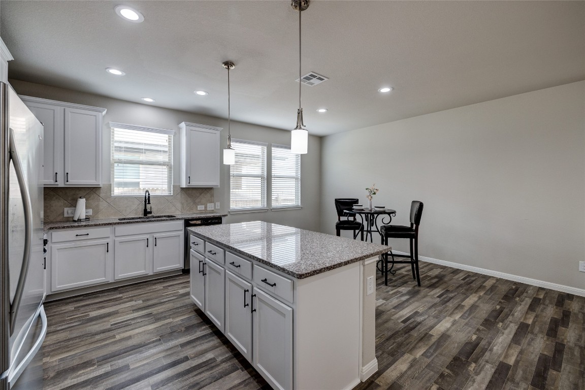 128 Shearwater Lane Leander, TX 78641 - Photo 14 of 30 a kitchen with sink cabinets and wooden floor