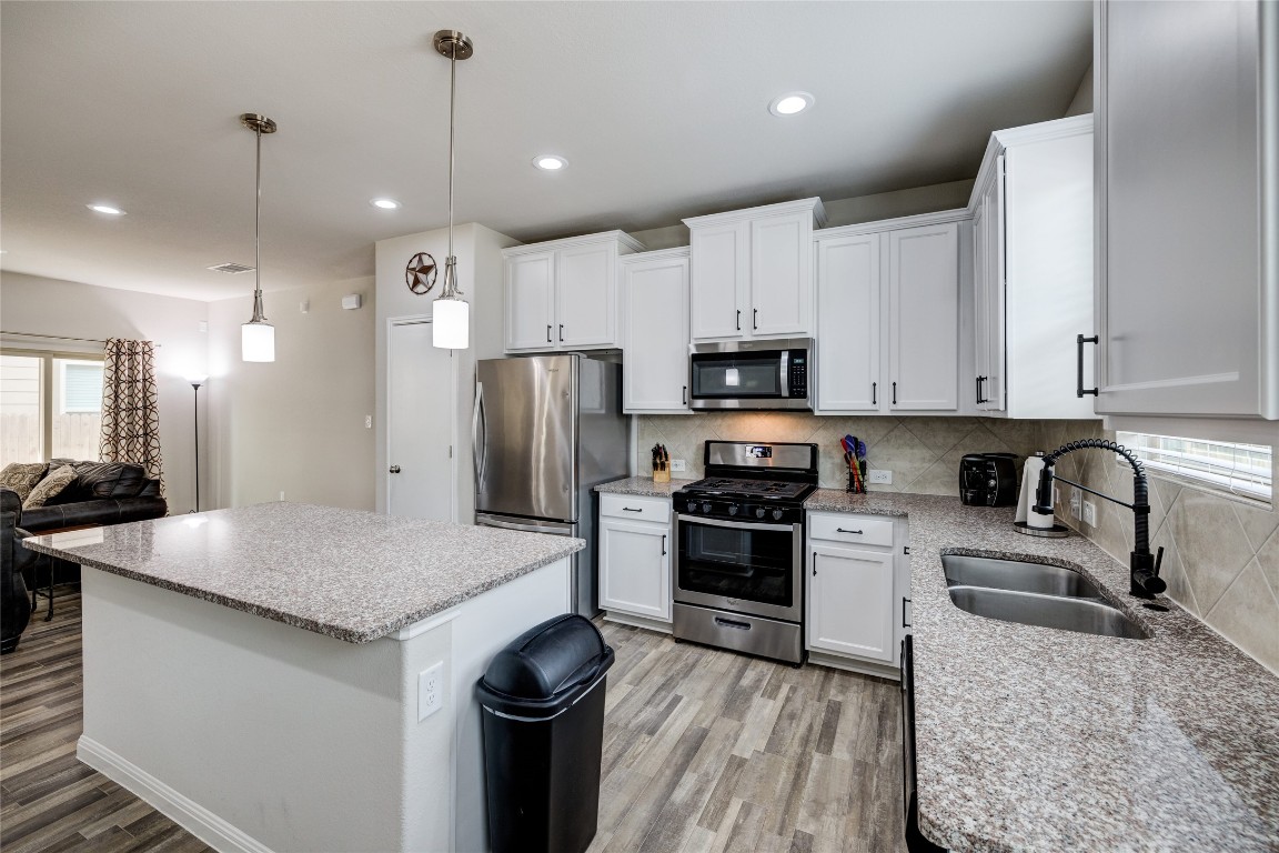 128 Shearwater Lane Leander, TX 78641 - Photo 28 of 30 a kitchen with granite countertop a sink stove and refrigerator