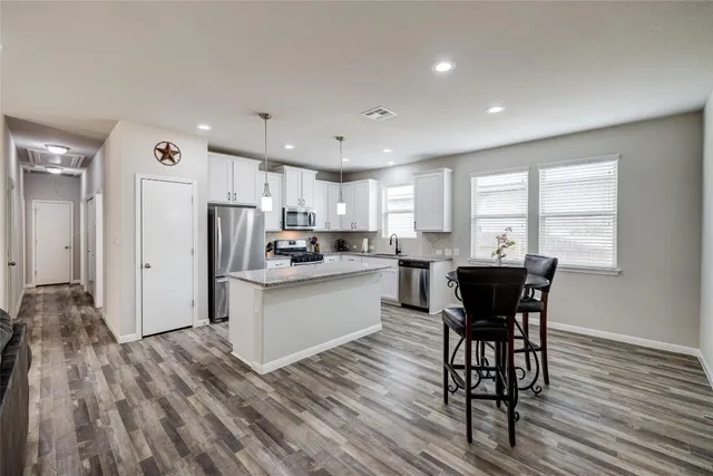 a kitchen with a stove and chairs