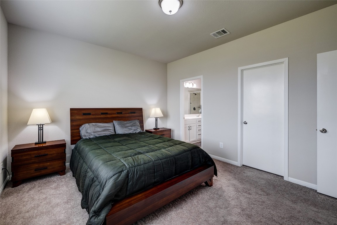 128 Shearwater Lane Leander, TX 78641 - Photo 23 of 30 a bedroom with a bed and a lamp