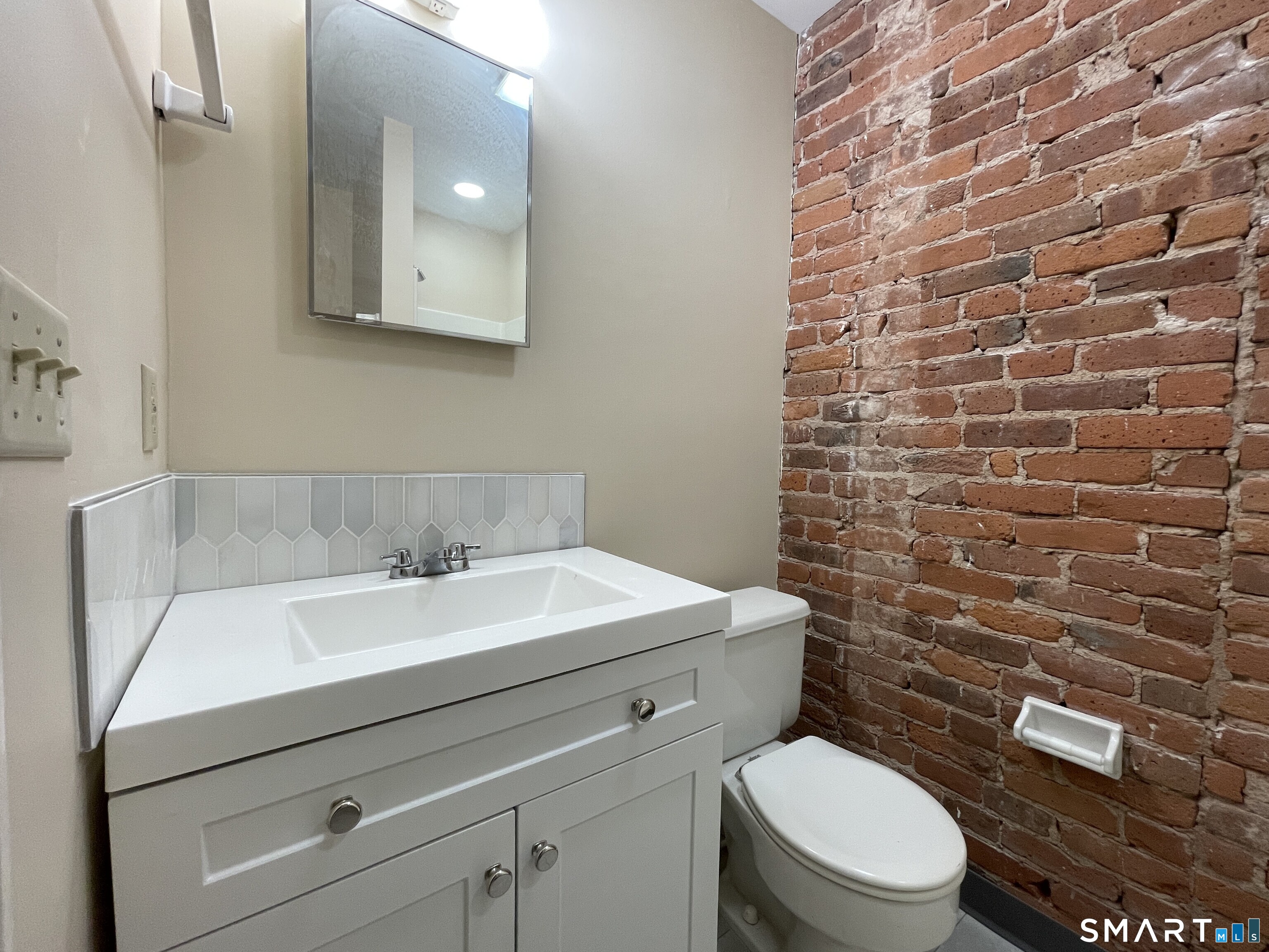 32 Trumbull Street, Unit 3 New Haven, CT 06511 - Photo 6 of 8 a bathroom with a toilet a sink and mirror