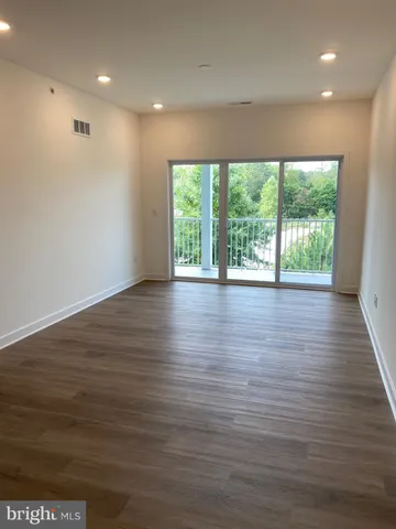 a kitchen with stainless steel appliances granite countertop a sink a refrigerator a microwave a stove and white cabinets with wooden floor