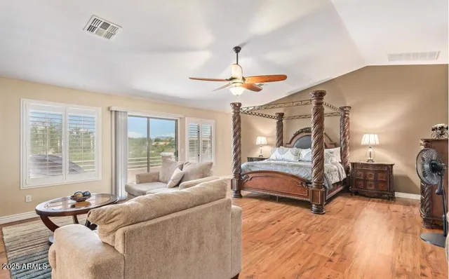 a bedroom with a bed and a chandelier fan