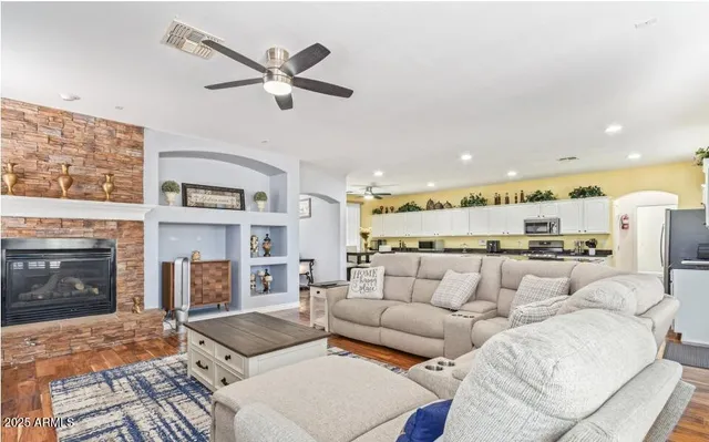 a kitchen with stainless steel appliances a stove a sink a refrigerator white cabinets and wooden floor