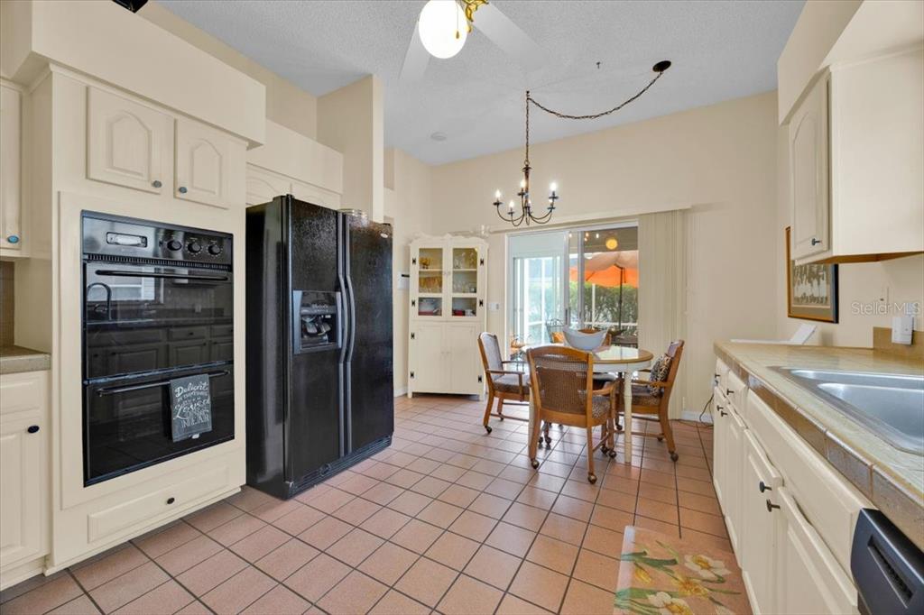 802 Miranda Way The Villages, FL 32159 - Photo 11 of 29 a kitchen with stainless steel appliances granite countertop a refrigerator and a stove top oven