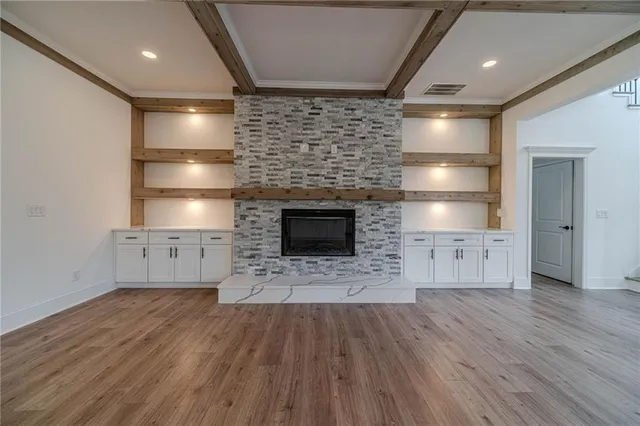 a view of an empty room with a fireplace and a ceiling fan