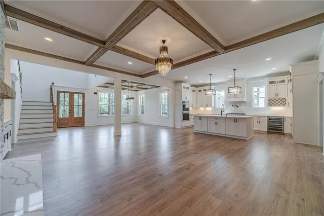 a kitchen with stainless steel appliances granite countertop a sink a stove and a wooden floors