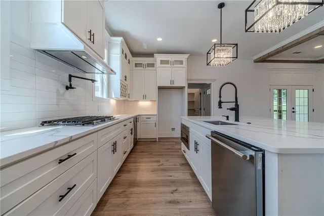 a large kitchen with stainless steel appliances granite countertop a stove and wooden floor