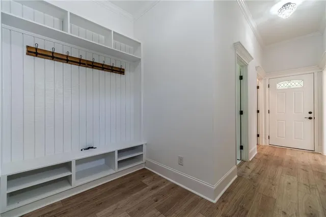 a view of an empty room with wooden floor and stairs