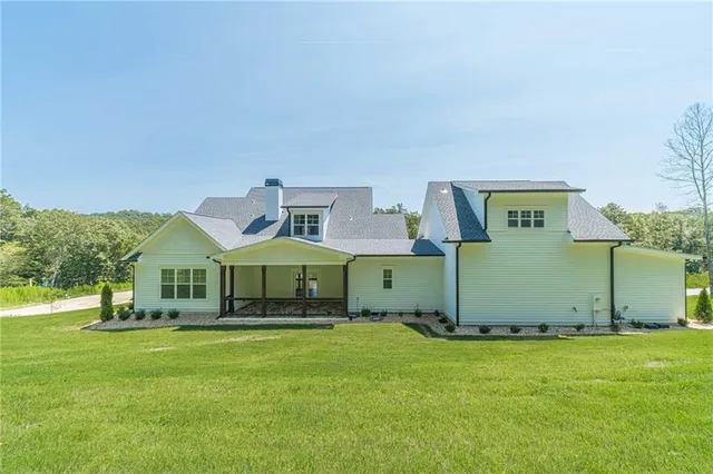 a front view of a house with yard and green space