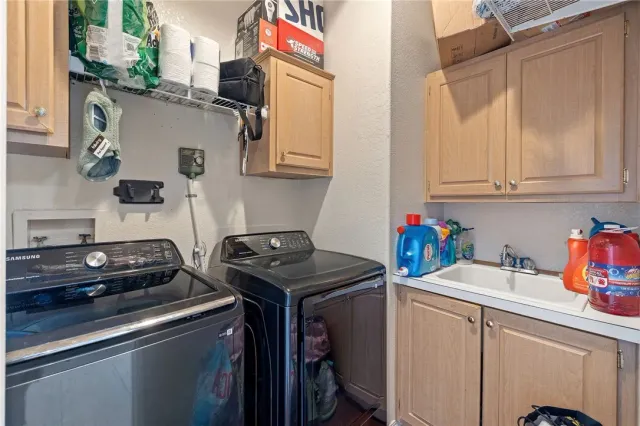 a utility room with sink dryer and washer