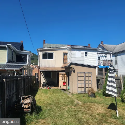 a view of a wooden house with a small yard