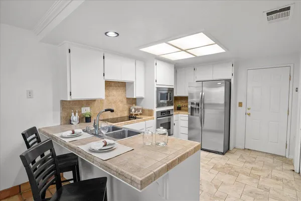 a view of kitchen with refrigerator stove dining table and chairs