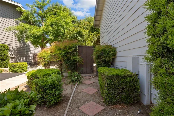 a backyard of a house with plants and outdoor seating