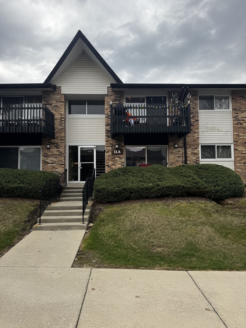 11 A Kingery Quarter, Unit 202 Willowbrook, IL 60527 - Photo 1 of 22 a front view of a house with a garden