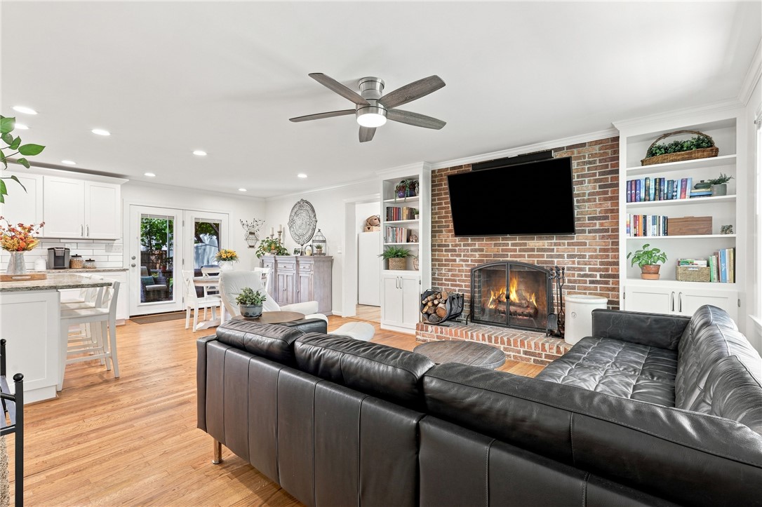 204 Sylvia Road Easley, SC 29642 - Photo 5 of 36 Warm and inviting living space with hardwood floors, a brick fireplace, and built-in shelving.