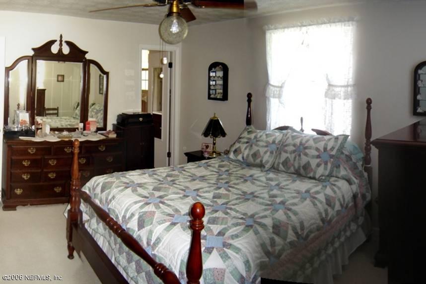 4170 Mustang Road Middleburg, FL 32068 - Photo 4 of 7 a bed room with a bed mirror and a dresser