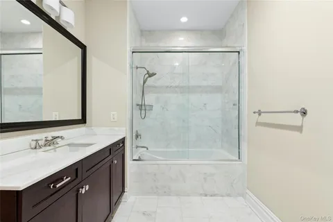 a bathroom with a shower sink vanity and mirror