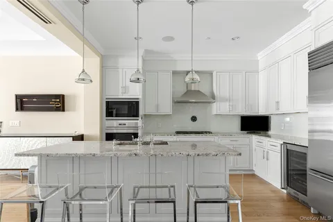 a large kitchen with stainless steel appliances kitchen island granite countertop a sink and a stove