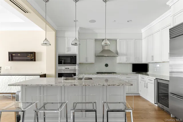 a large kitchen with stainless steel appliances kitchen island granite countertop a sink and a stove