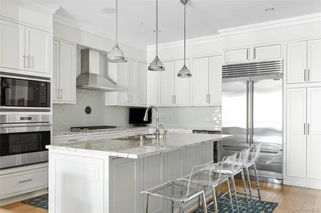 a kitchen with kitchen island granite countertop a sink cabinets and stainless steel appliances