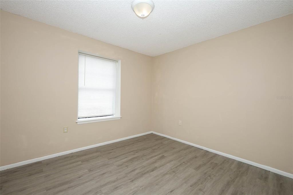 3240 Littlefield Street Deltona, FL 32738 - Photo 15 of 18 an empty room with wooden floor and windows