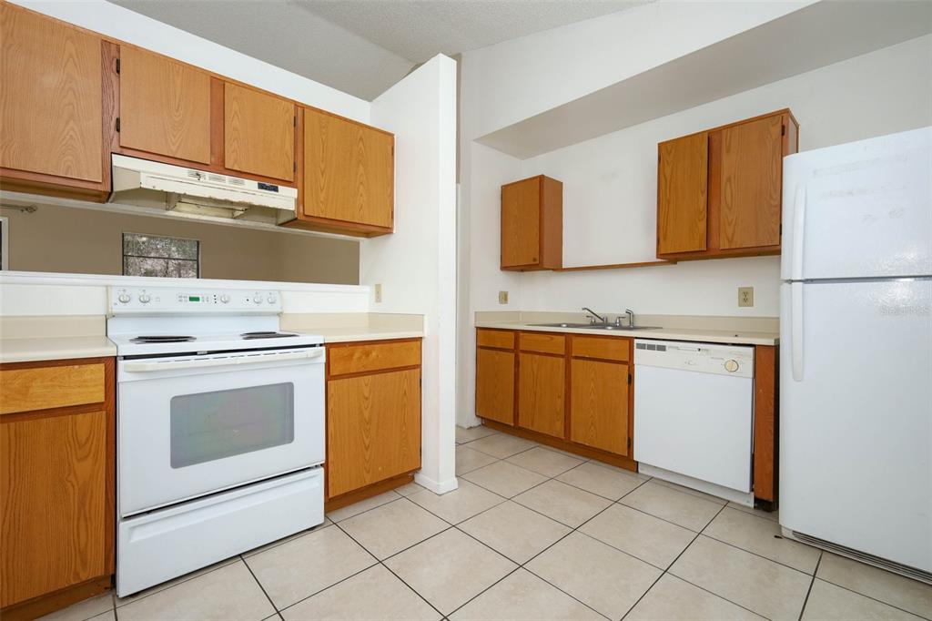 3240 Littlefield Street Deltona, FL 32738 - Photo 5 of 18 a kitchen with a stove sink and a refrigerator