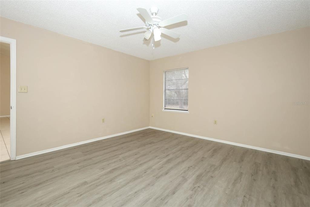 3240 Littlefield Street Deltona, FL 32738 - Photo 8 of 18 an empty room with wooden floor and windows