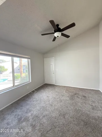 an empty room with a window and a fan