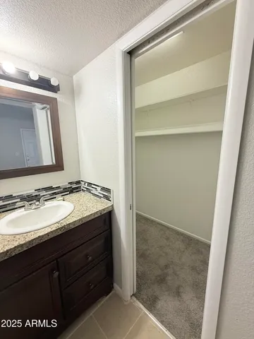 a bathroom with a granite countertop sink and a mirror