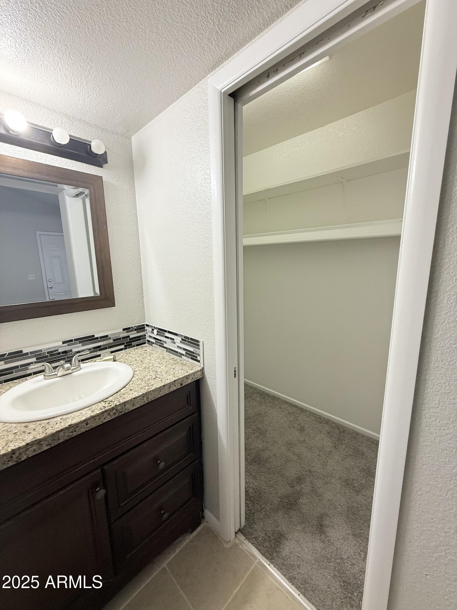 19601 North 7th Street, Unit 1030 Phoenix, AZ 85024 - Photo 14 of 19 a bathroom with a granite countertop sink and a mirror
