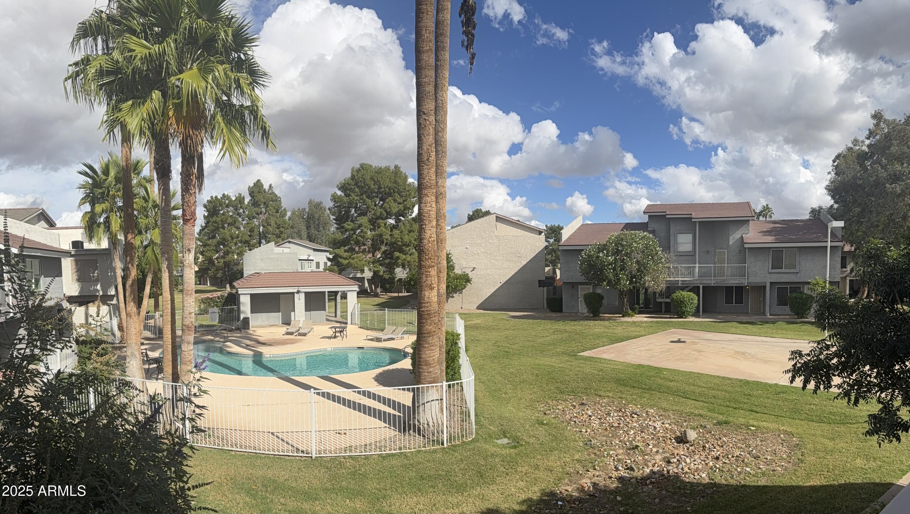 19601 North 7th Street, Unit 1030 Phoenix, AZ 85024 - Photo 19 of 19 a view of a white house with a swimming pool and a yard