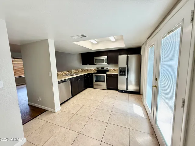 a kitchen with stainless steel appliances a stove a sink and a refrigerator
