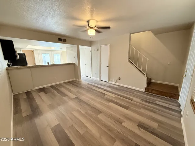 a view of a livingroom with wooden floor and chandelier