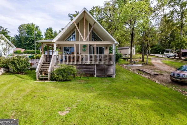 a view of a house with a big yard potted plants and large tree