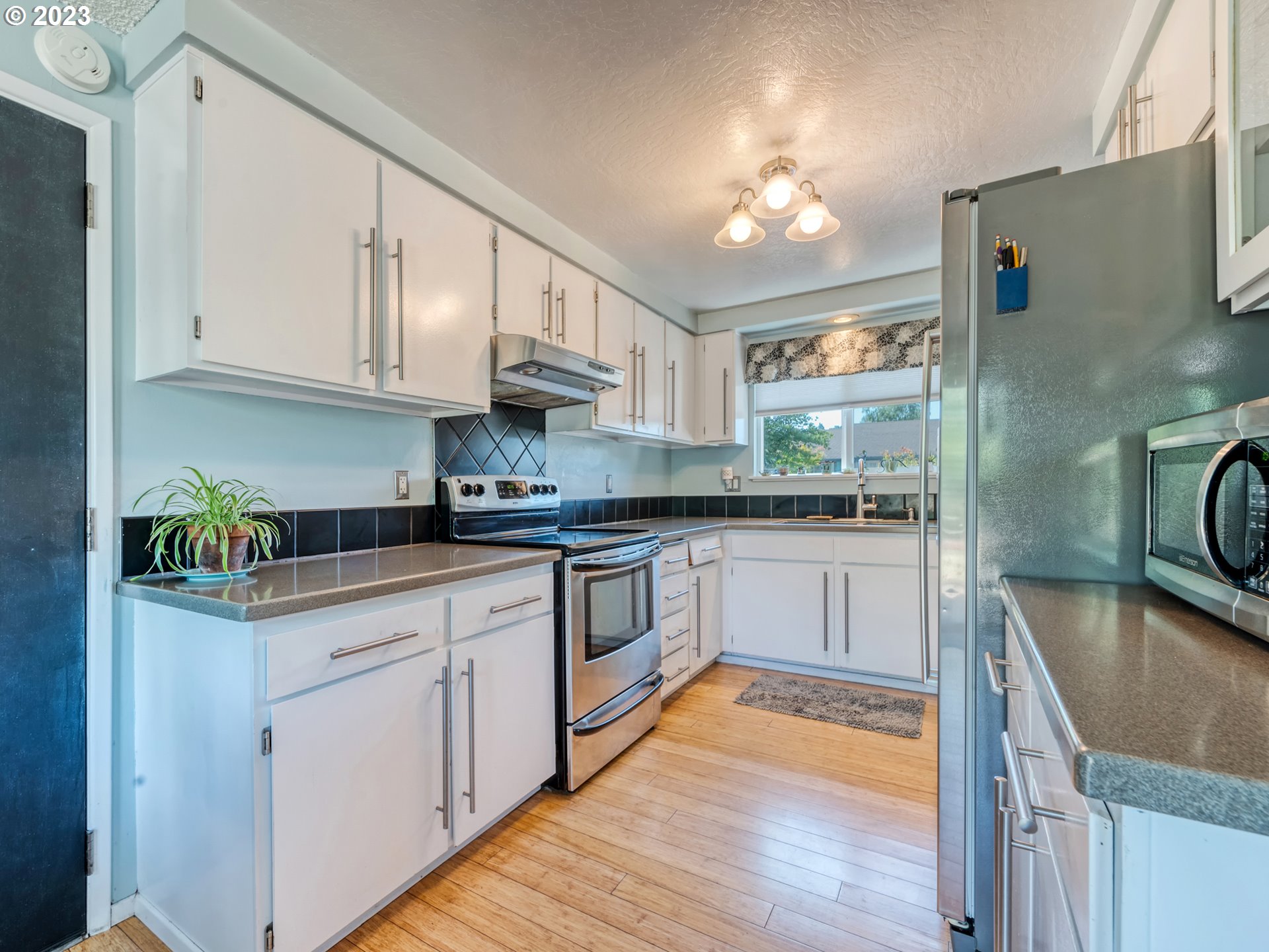636 Island Street Springfield, OR 97477 - Photo 11 of 25 a kitchen with granite countertop a sink a counter top space and cabinets