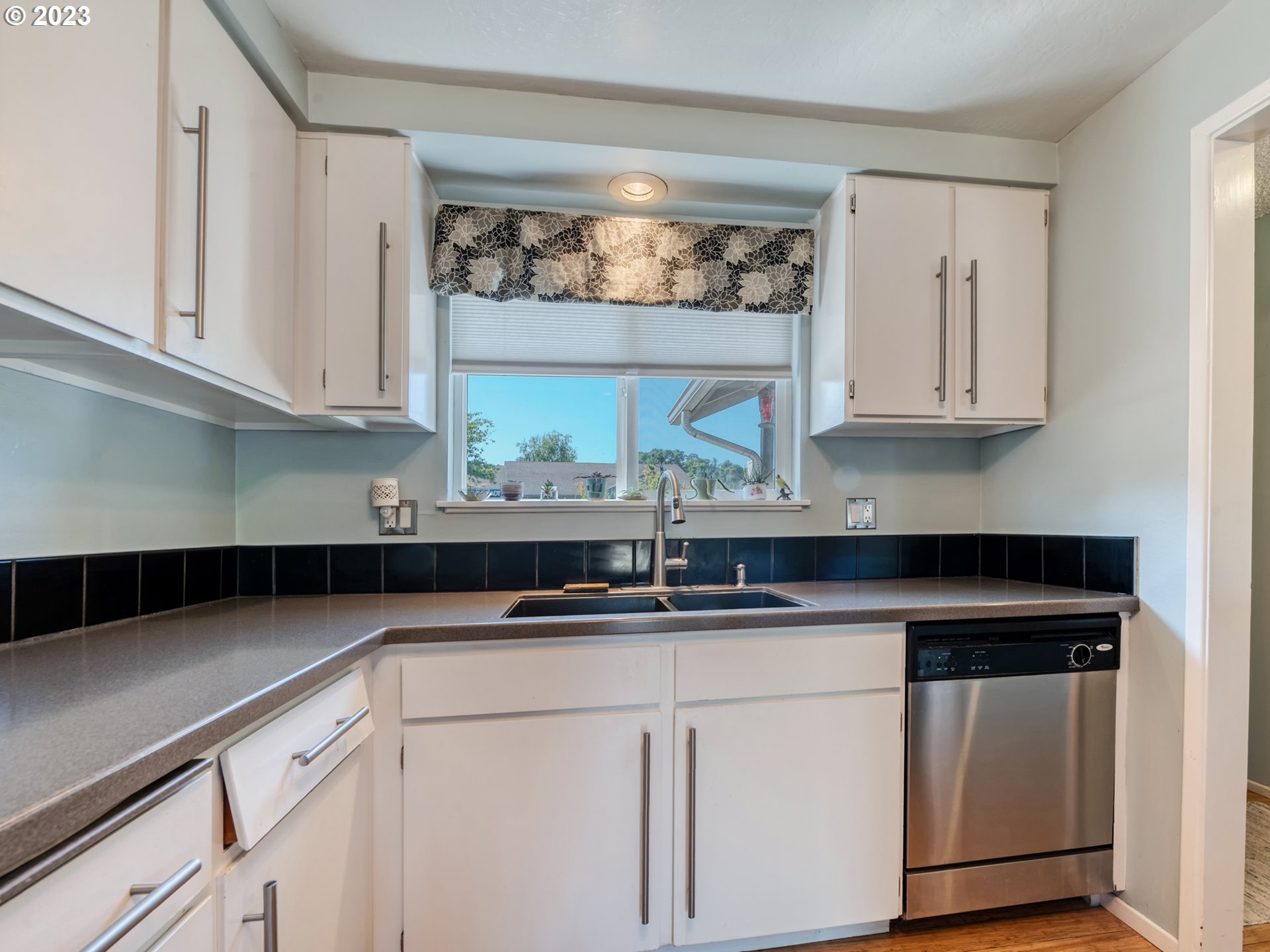636 Island Street Springfield, OR 97477 - Photo 12 of 25 a kitchen with stainless steel appliances granite countertop white cabinets sink and window