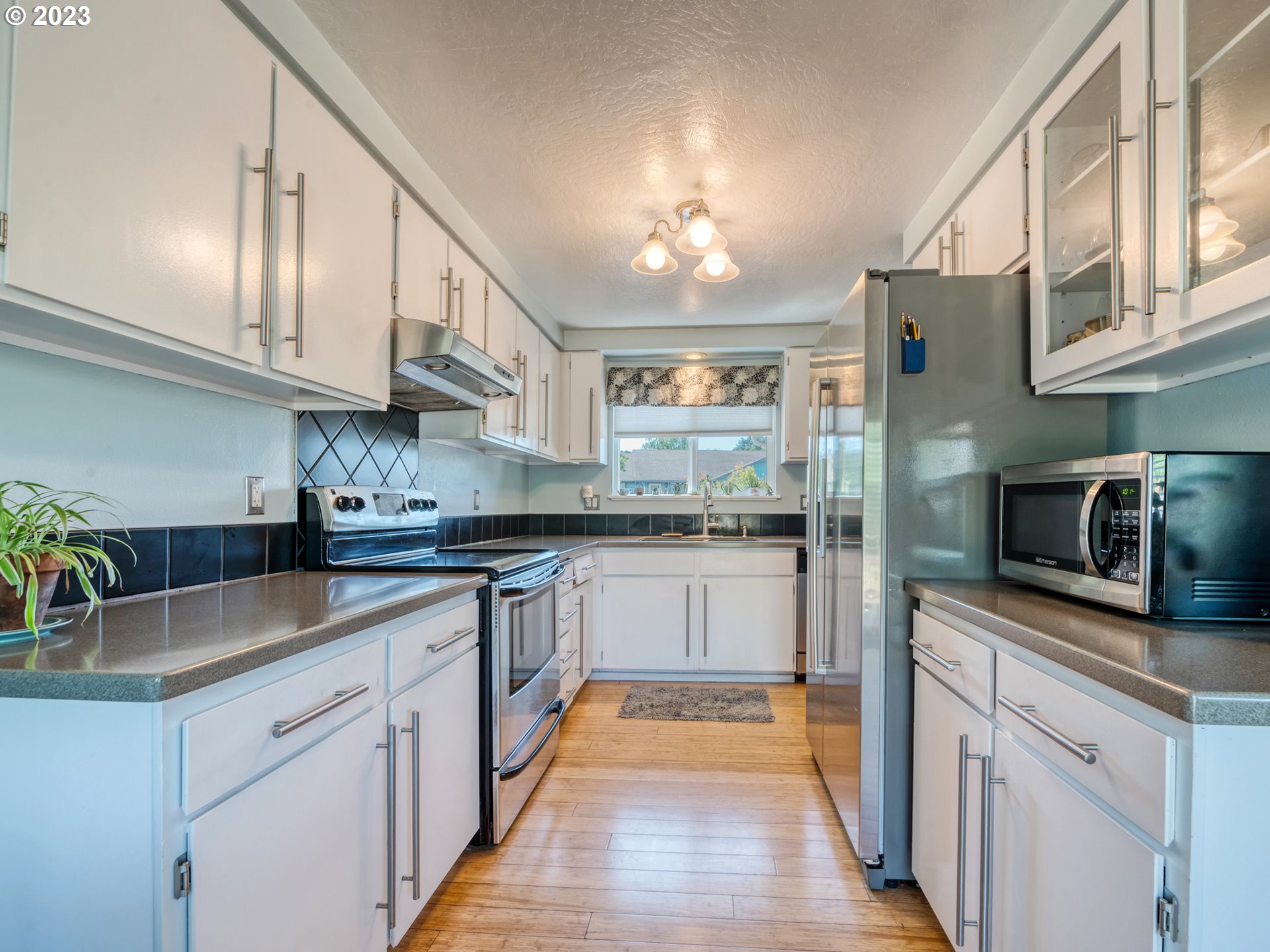 636 Island Street Springfield, OR 97477 - Photo 9 of 25 a kitchen with granite countertop stainless steel appliances and wooden cabinets