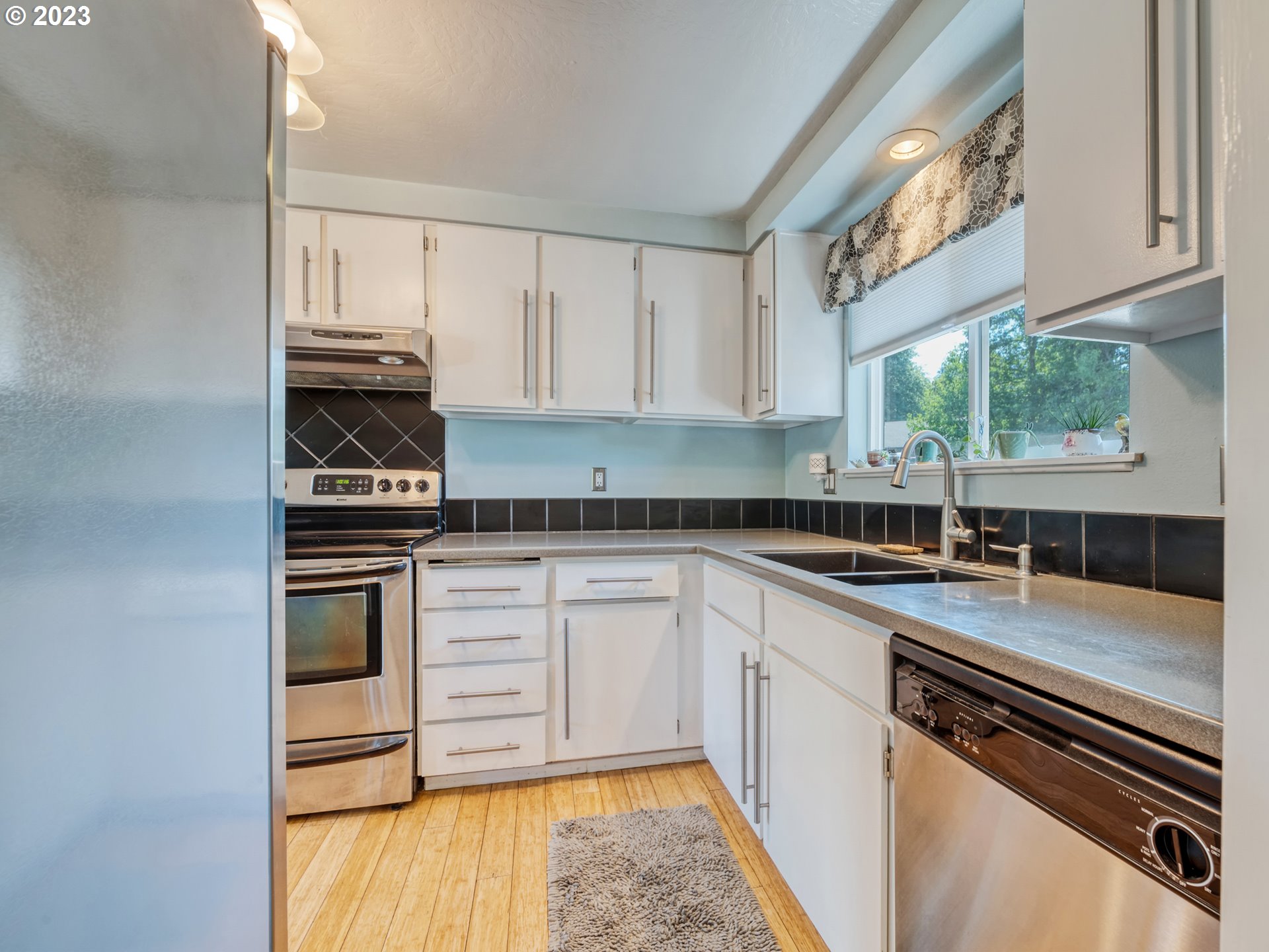 636 Island Street Springfield, OR 97477 - Photo 10 of 25 a kitchen with stainless steel appliances a stove sink and cabinets