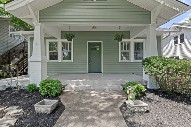 a view of a house with a yard and potted plants