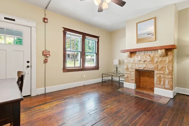 a view of an empty room with window and wooden floor