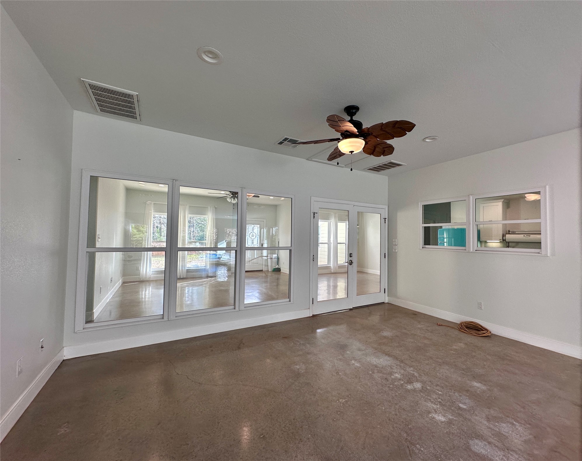 124 Pine Path Bastrop, TX 78602 - Photo 20 of 31 In pool room looking through French doors into Family room with concrete flooring