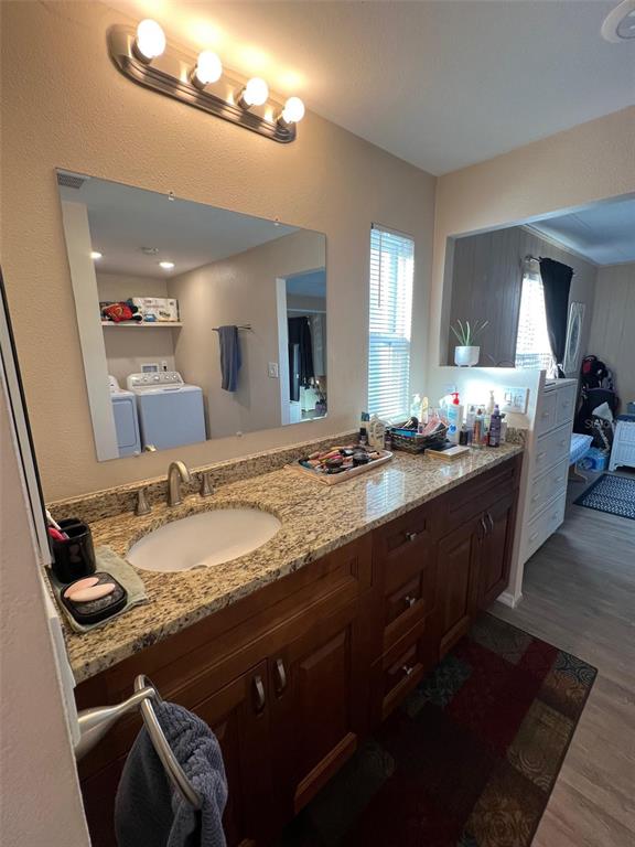 29250 US Highway 19 North, Unit 446 Clearwater, FL 33761 - Photo 28 of 30 a bathroom with a granite countertop sink a large mirror and a shower