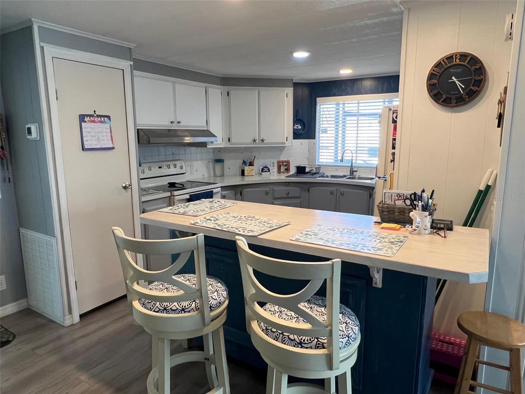 29250 US Highway 19 North, Unit 446 Clearwater, FL 33761 - Photo 7 of 30 a kitchen with granite countertop a dining table chairs and a refrigerator