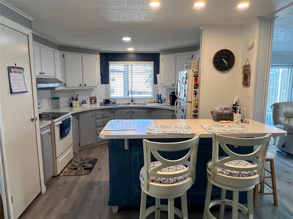 29250 US Highway 19 North, Unit 446 Clearwater, FL 33761 - Photo 8 of 30 a kitchen with a sink a stove and chairs