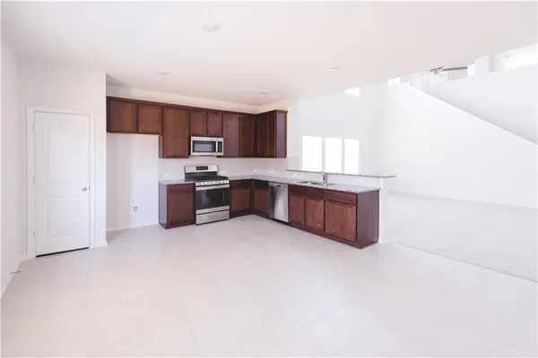a large kitchen with stainless steel appliances granite countertop a stove and a sink