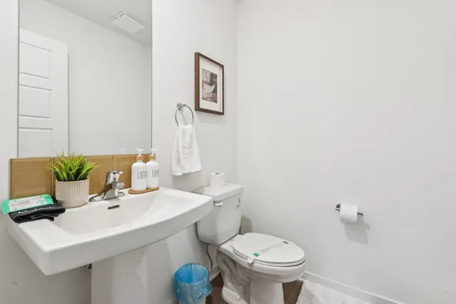 a bathroom with a sink mirror and toilet