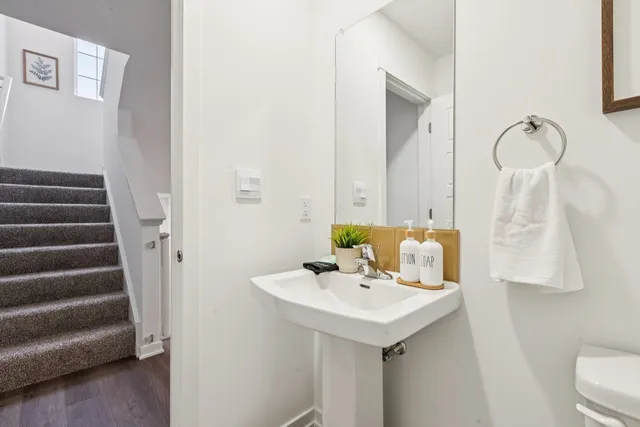 a bathroom with a sink and mirror with toilet